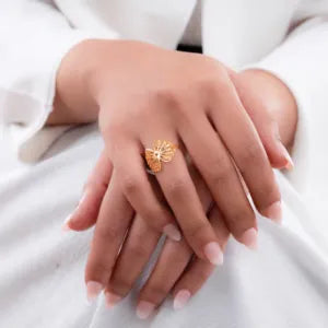 خاتم عيار 18 بتصميم زهرة من غامية، يظهر تفاصيل الزهرة الراقية والمعادن اللامعة.